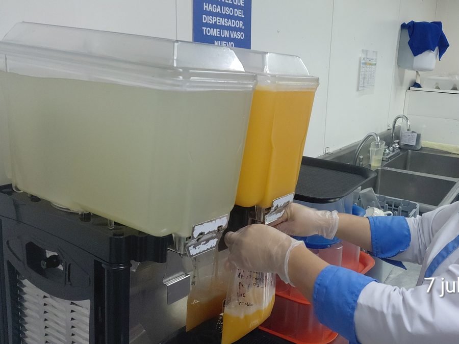 Personal de SICMAR sirviendo bebidas desde el dispensador de la estación de hidratación
