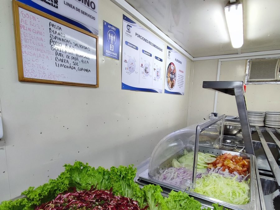Barra de frutas y ensaladas frescas montada en el comedor del campamento