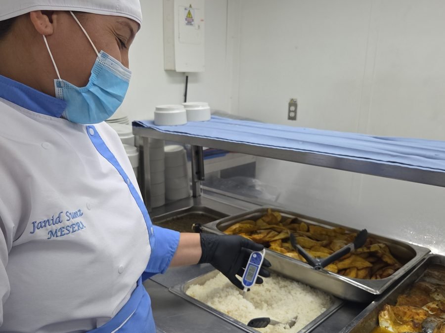 Personal de cocina de SICMAR emplatando en línea caliente con cofia, tapabocas y guantes