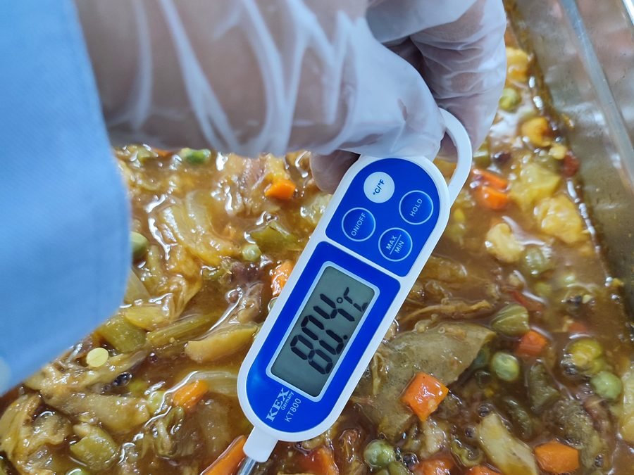 Control de temperatura de un guiso en la línea caliente con termómetro digital