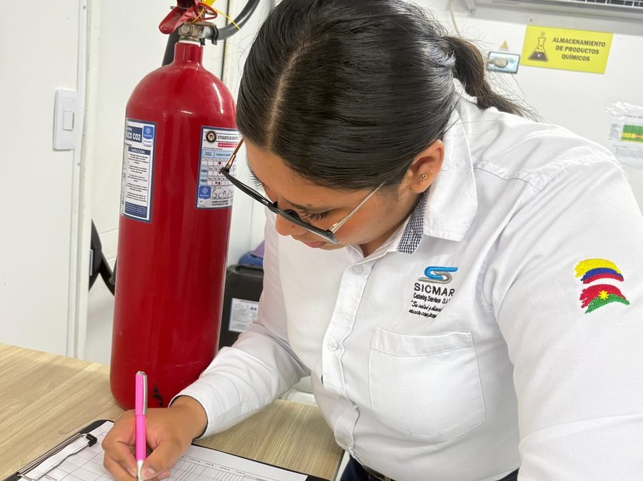 Coordinadora HSEQ diligenciando la lista de chequeo de un extintor