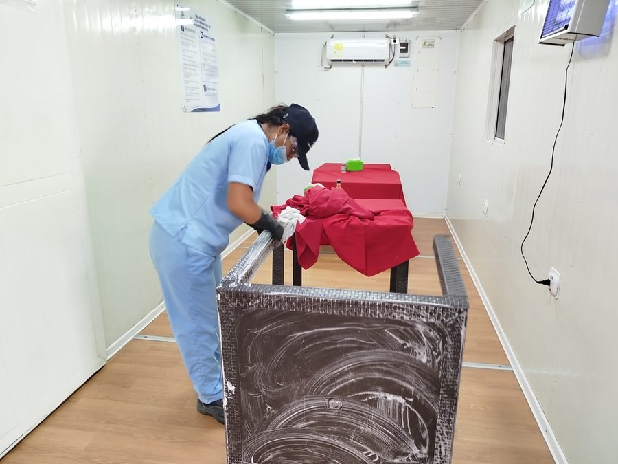 Auxiliar organizando la lencería y ropa de cama de una habitación