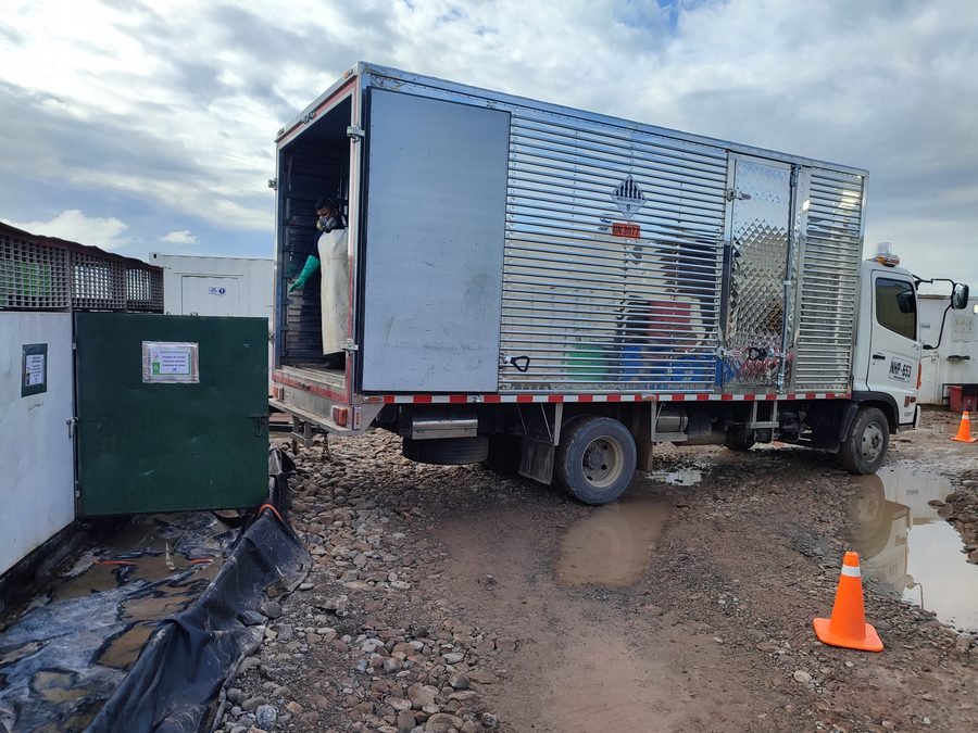 Vehículo rotulado de transporte de alimentos de SICMAR en locación, con personal de dotación completa